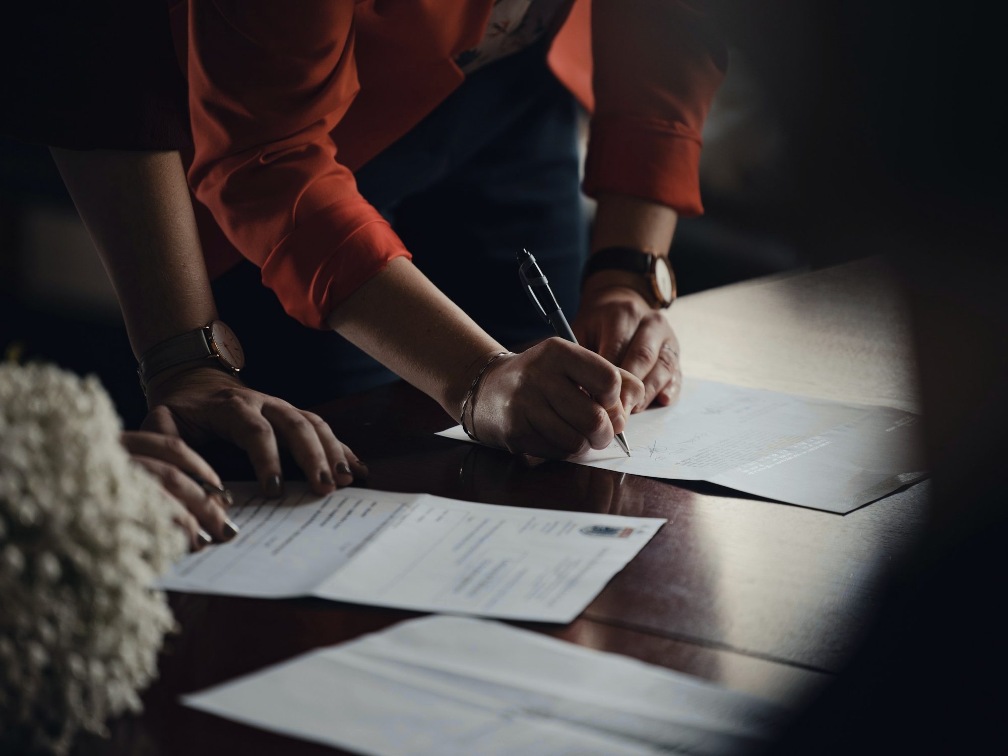 Hands signing a document