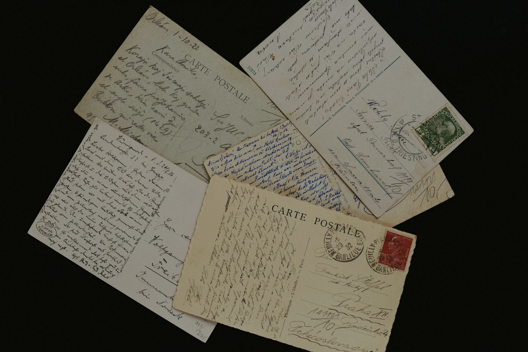 Handwritten postcards and letters on a dark table