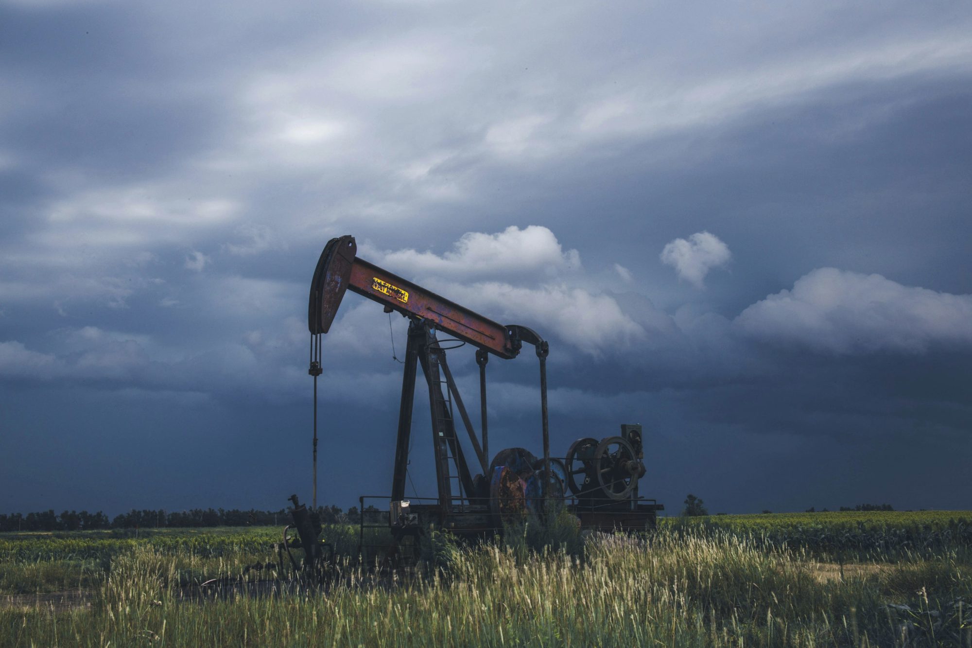 An oil pumpjack under a stormy sky
